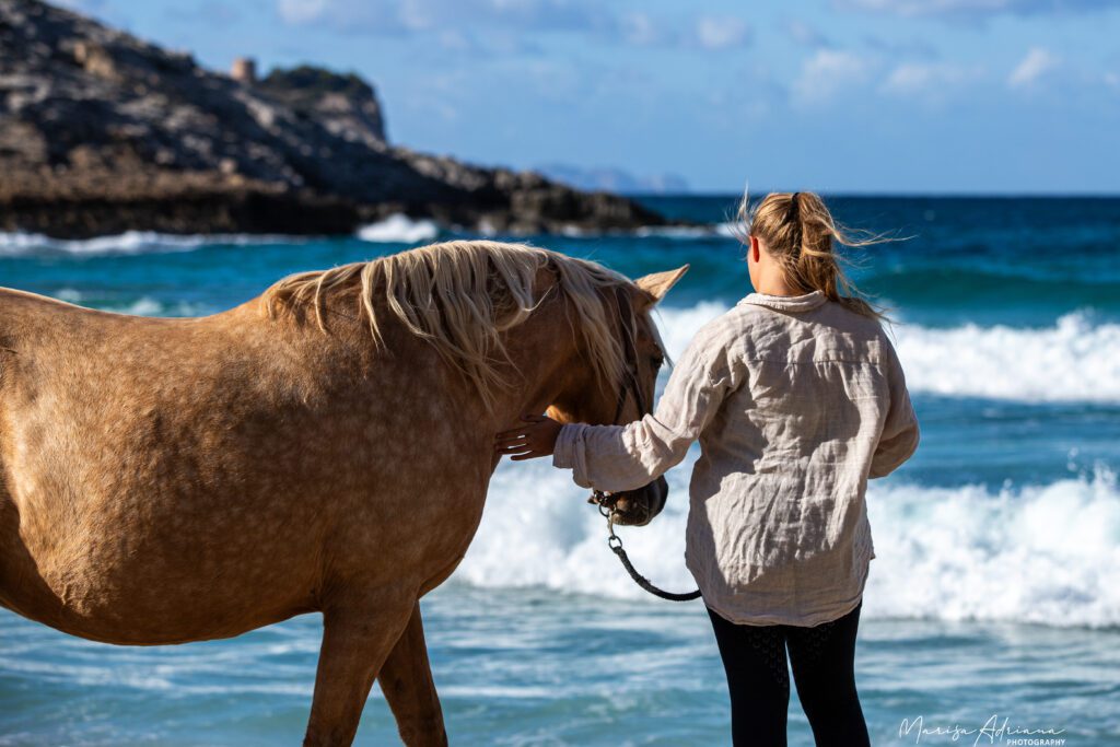 Girl with horse on beach