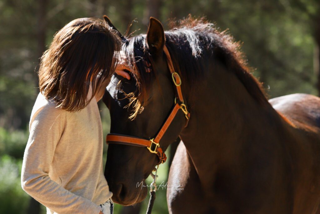 Lady and nuzzling horse